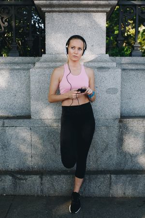 Woman with sportswear listening to music with headphones