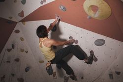 Young woman climbing on wall