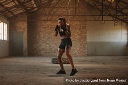 Woman doing shadow boxing exercise in empty factory shade 42k7yb