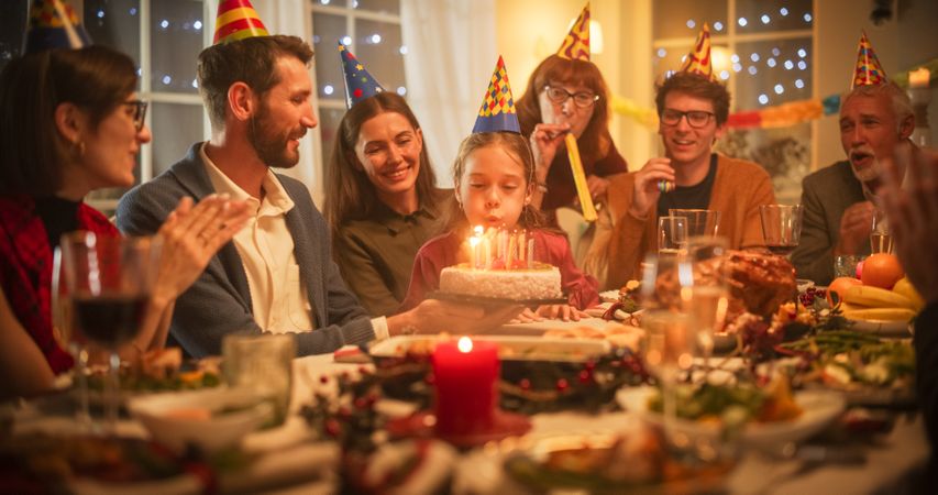 Young Handsome Father Bringing a Birthday Cake with Candlelights to His Cute Daughter.