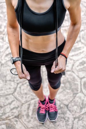 Woman posing with skipping rope in a park