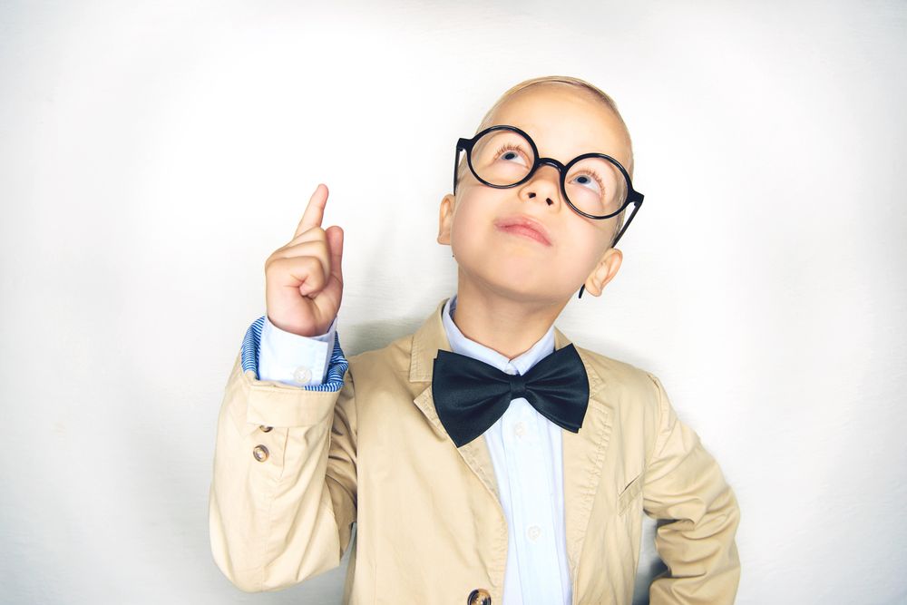 Blond boy looking up in glasses with bow tie
