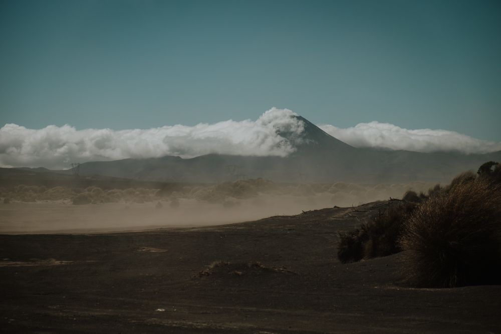 Dusty valley against high mountains in clouds