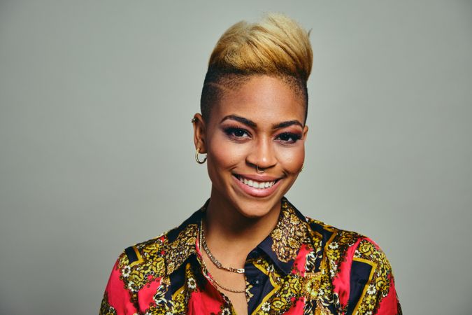 Portrait of professional Black woman with short blonde hair in bold patterned shirt