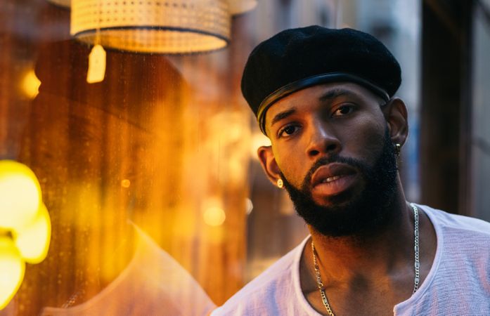 Black man near a glass. reflection and warm light