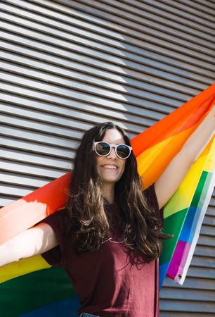 Woman posing happily with the LGBTQI flag