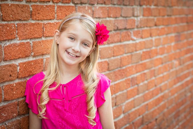Cute Young Girl Portrait Against A Brick Wall