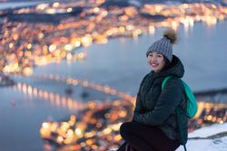 Joyful millennial woman enjoying view of night city