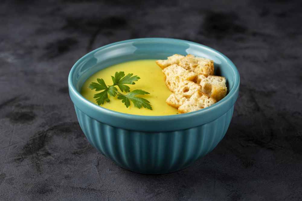 Bowl with onion soup and croutons on the table.