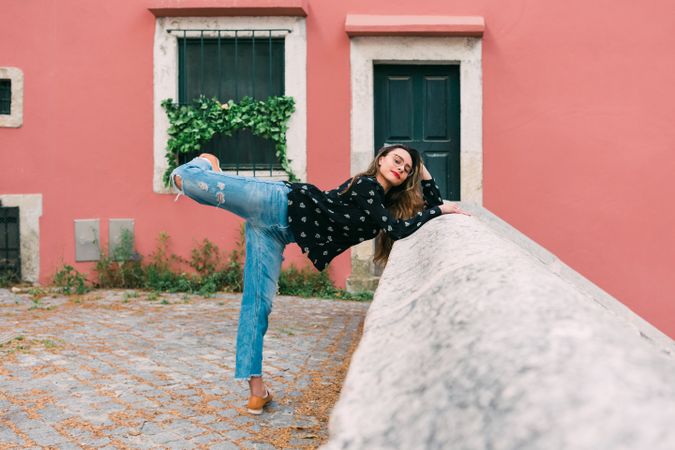 Casual woman dancing on old city street