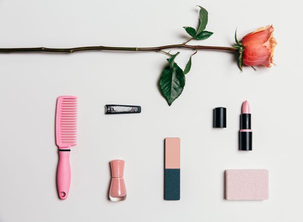 Feminine accessories in pink tones over plain background