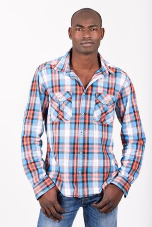 Studio shot of male in plaid shirt and jeans standing tall
