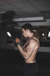 young fitness man doing weights