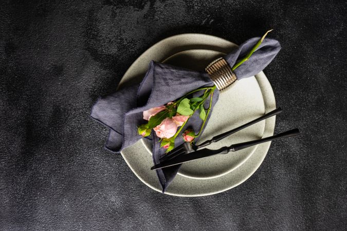 Flowers wrapped with navy napkin on grey plate