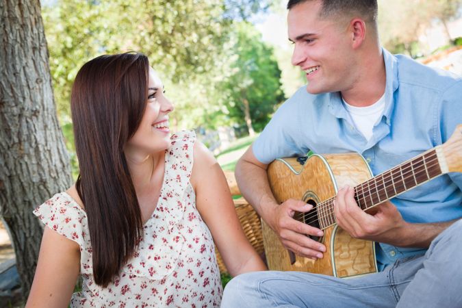 Man Playing Guitar for His Girlfriend in the Park.
