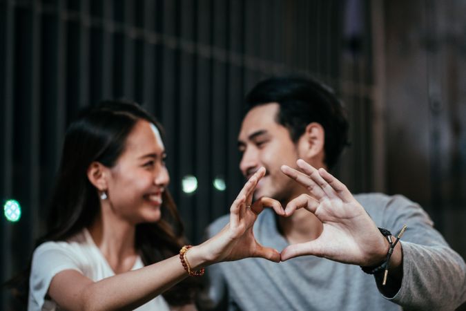 Asian couple hard making heart shape and gazing eyes together