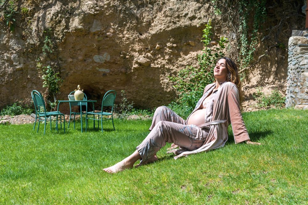 Pregnant woman enjoying the sun while sitting on the grass