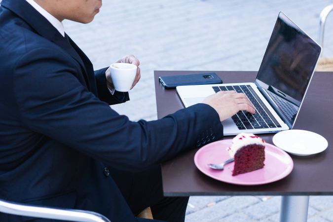 Businessman eating dessert in street cafe