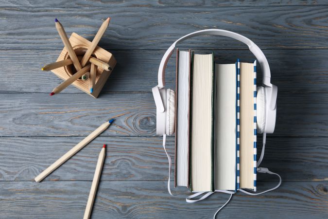 Concept of audiobook with books and headphones, top view
