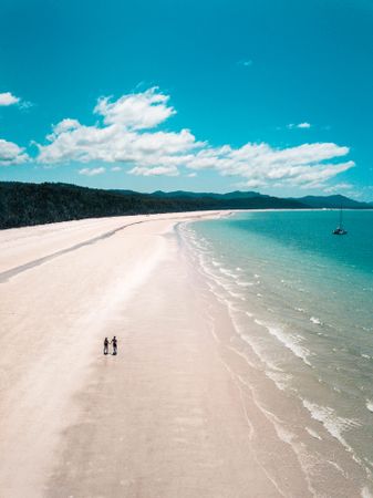 High angle view of two people walking on beach