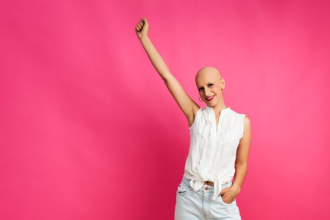 Optimistic woman after chemotherapy on pink background concept fights cancer