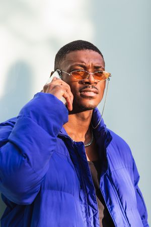 Trendy Black man on smartphone in city
