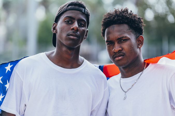 Black men wrapped in American Flag outside