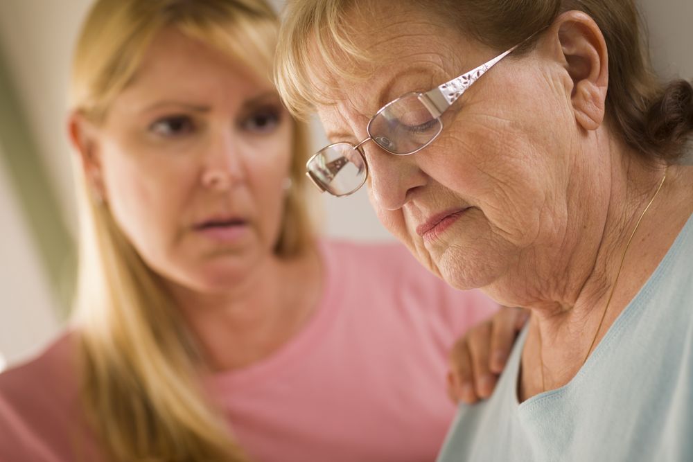 Young Woman Consoles Older Adult Female