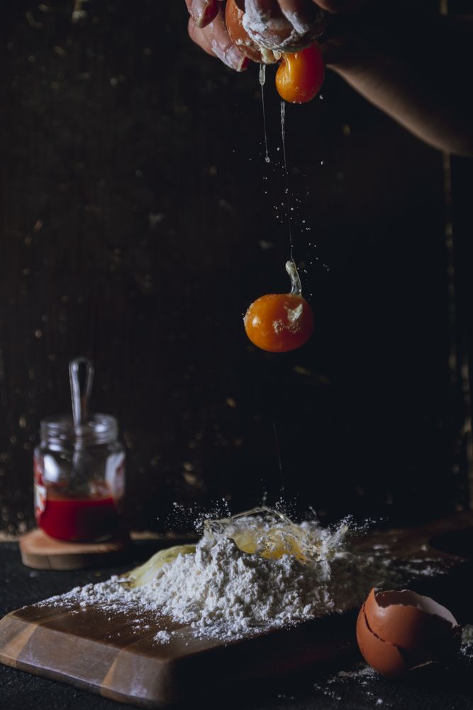 Cook preparing dough and breaking eggs
