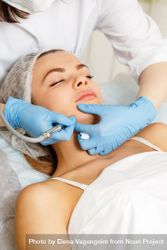 Woman having facial beauty treatment with machine on her jawline, vertical 5qGvEb