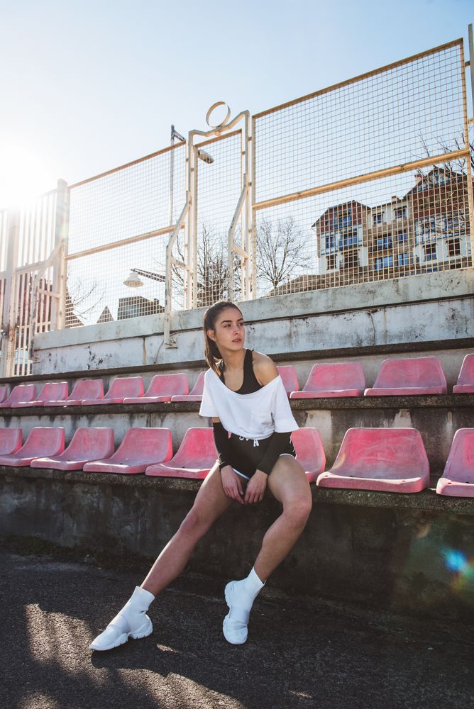 Young sportswoman resting on shabby seat