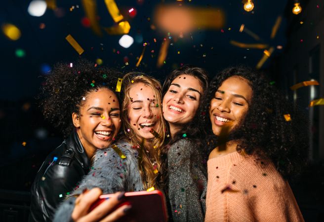 Multi-ethnic group of women taking a selfie at a party outside