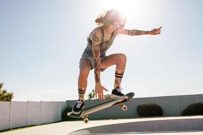 Female skater practicing skateboarding at skate park