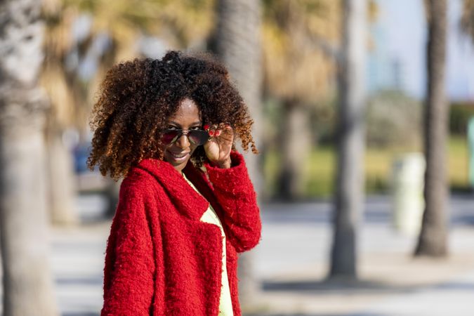 Female’s eyes over her sunglasses on street with palm trees
