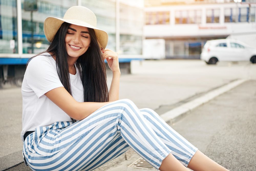 Woman sitting on curb relaxing with eyes closed