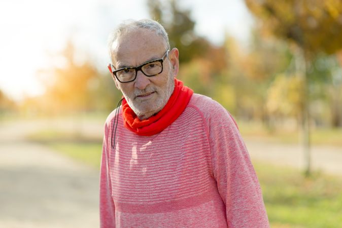 Portrait of older male standing in park with late afternoon sunlight