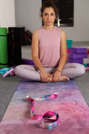 Woman in lotus pose among sports equipment