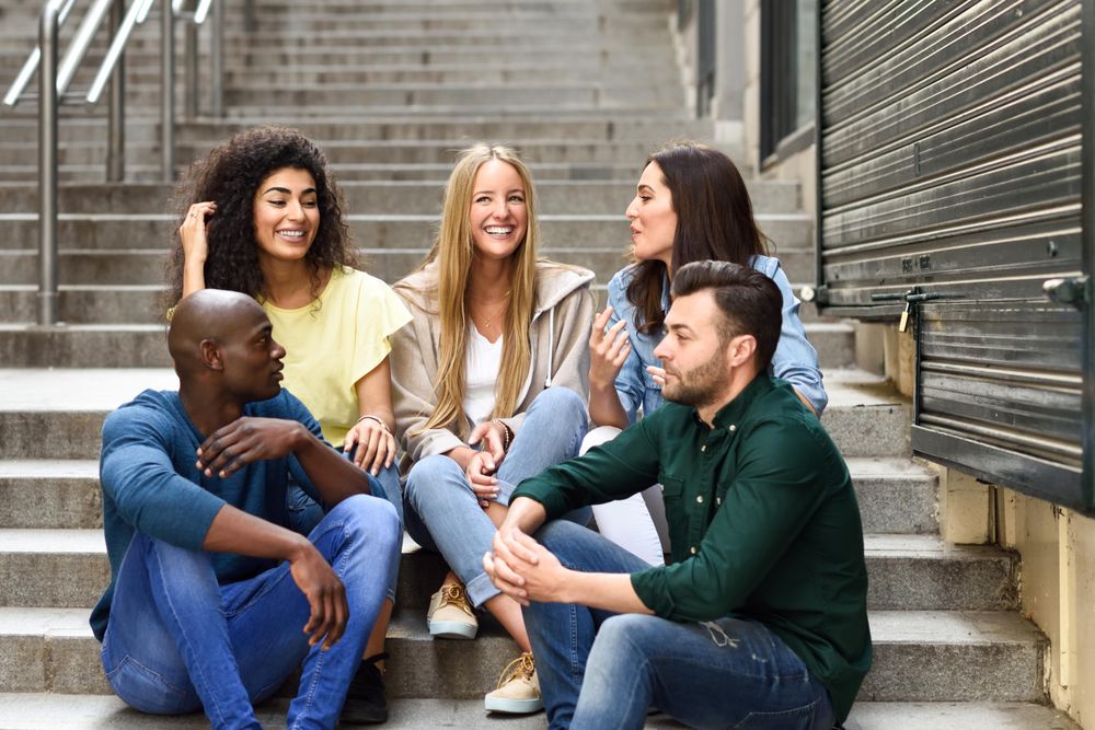 Friends sitting and chatting on outdoor cement staircase