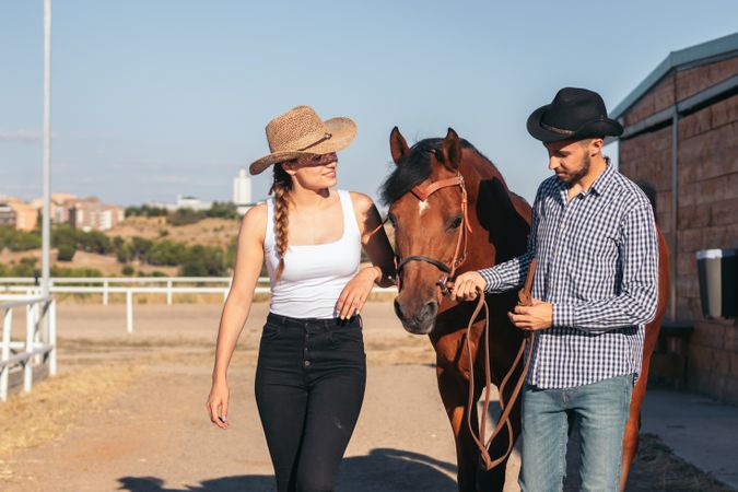 Friends walking with a horse in an equestrian center