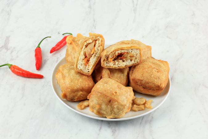 Plate of Indonesian fried stuffed tofu on marble table