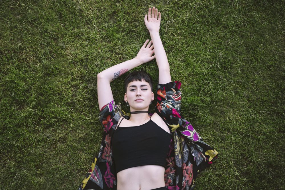 Woman in colored shirt lying on grass