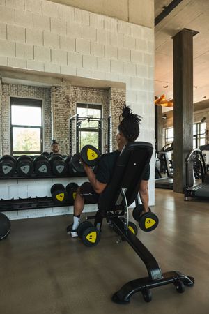 Strong man exercising with dumbbells in gym