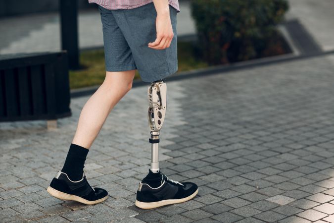 Cropped image of young man with prosthetic leg walking