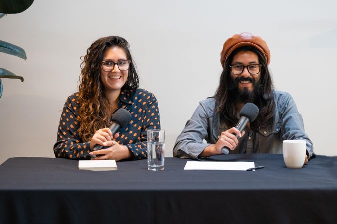 Man and woman smiling while on a panel