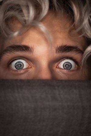 Young man's surprised blue eyes
