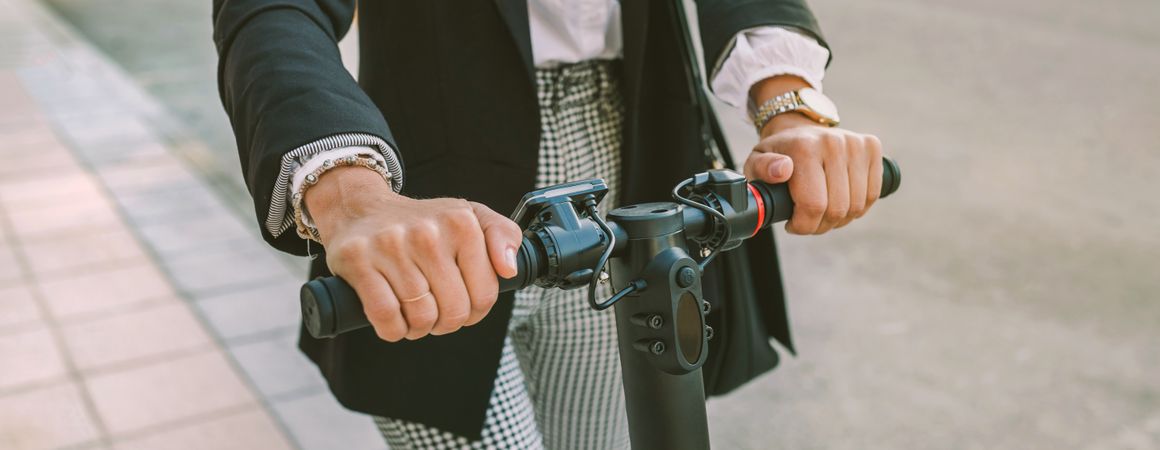 Unrecognizable businesswoman with e-scooter outdoors