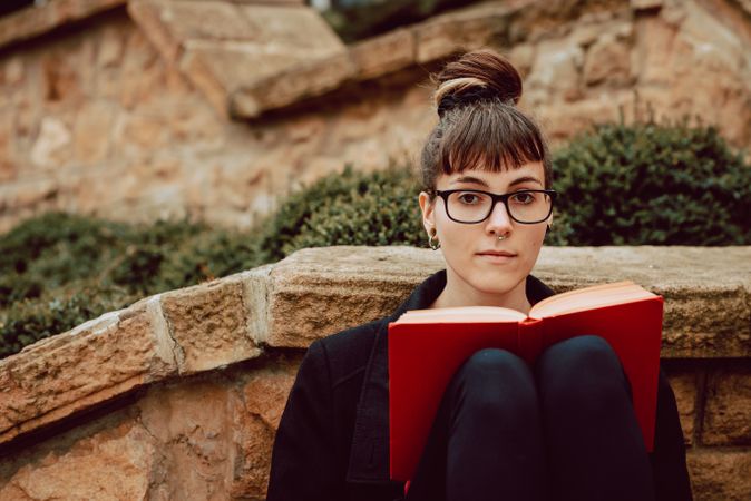 Young woman reading book on steps