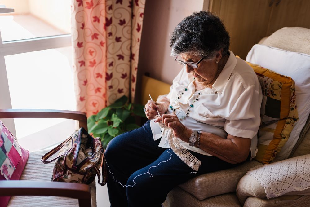 Mature female taking knitting tools at home