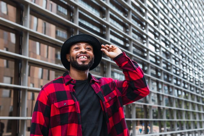 Cheerful Black man in stylish outfit on street