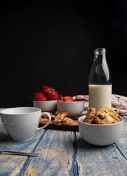 Glasses near fruits and cookies on table near napkin